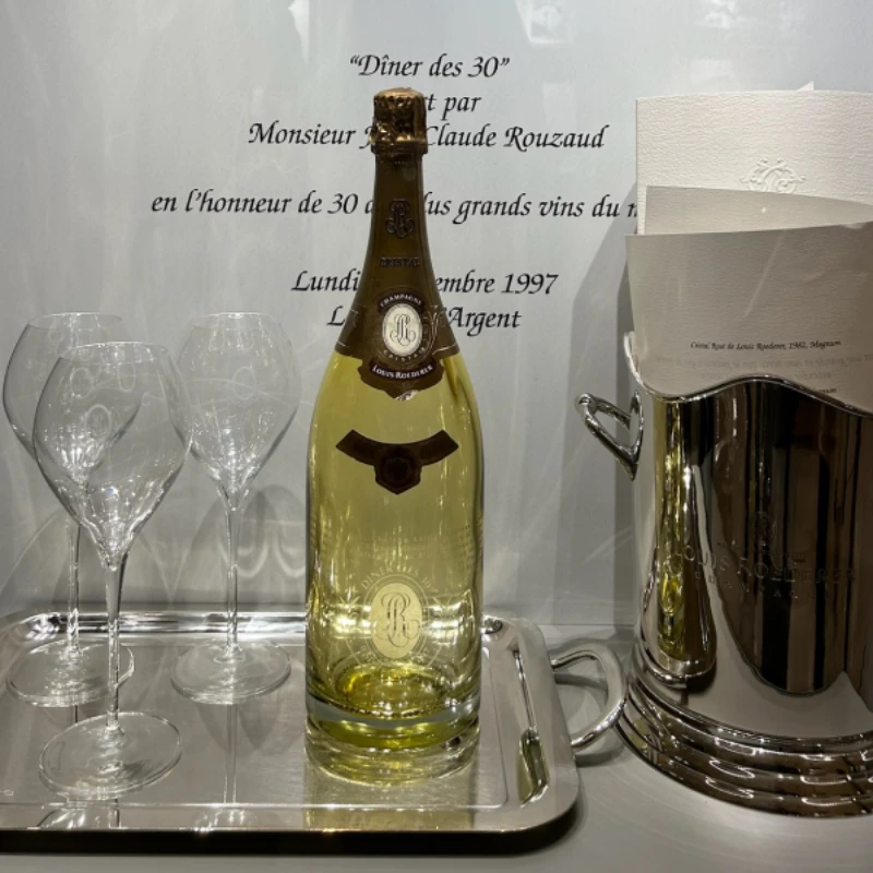 Presentation of a bottle of Louis Roederer champagne with glasses and cooler