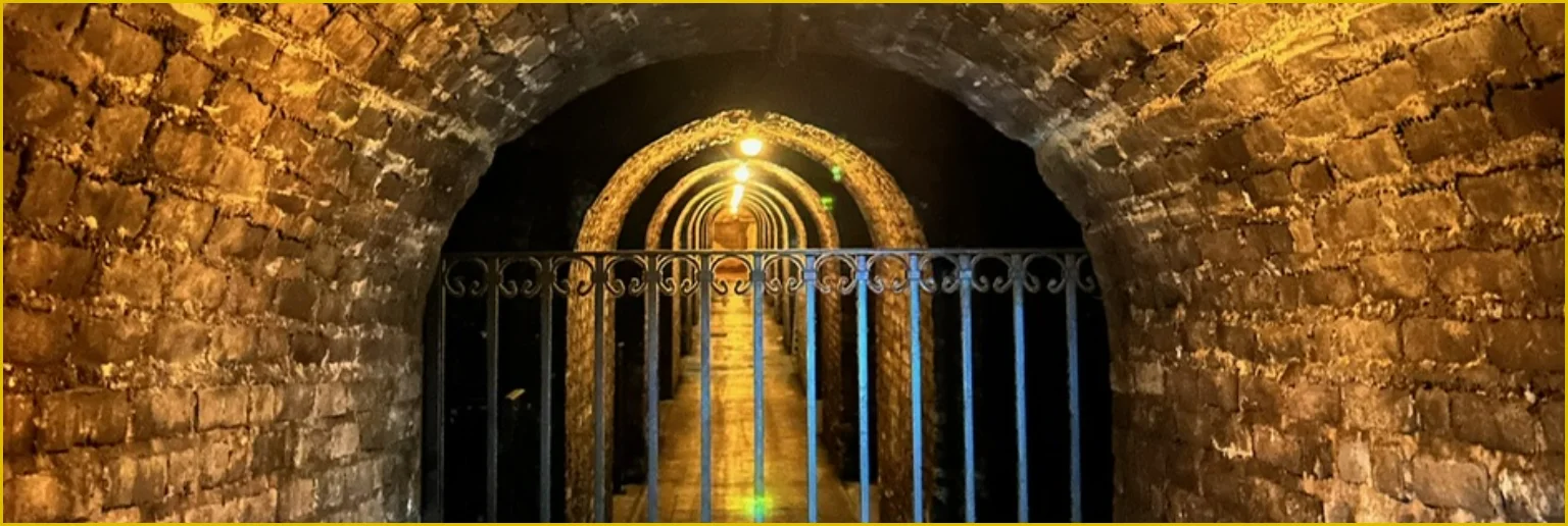 Underground champagne cellars with stone arches and gated entrance